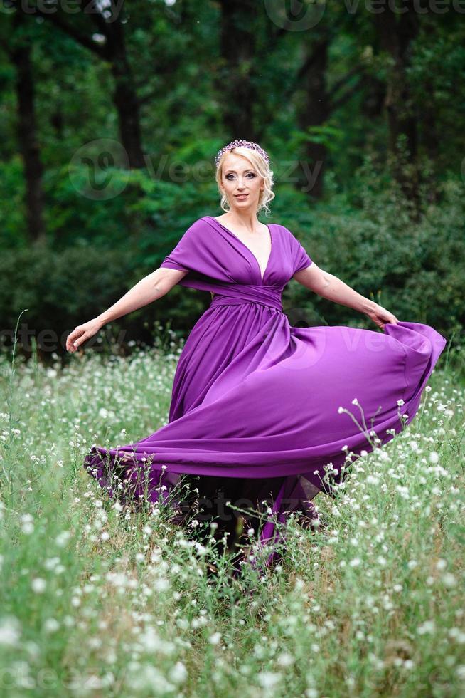 loira modelo de menina em um vestido lilás com um buquê foto