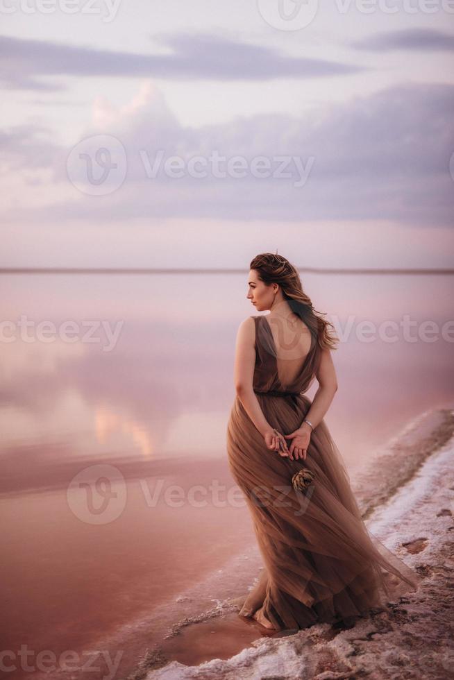 garota na margem de um lago salgado rosa foto