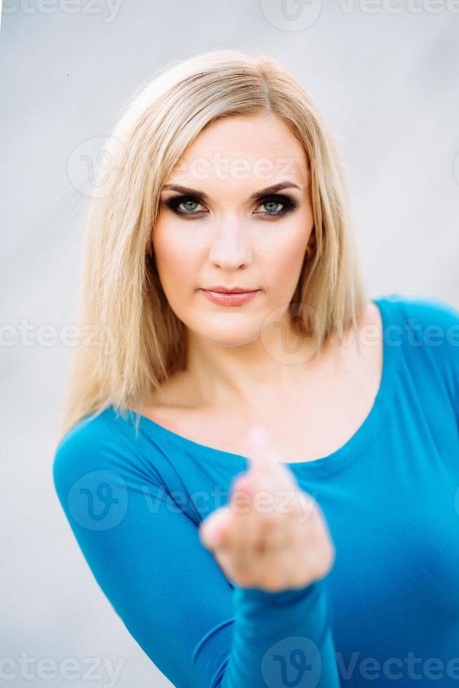 menina loira em um vestido azul com olhos azuis em uma pedreira de granito foto