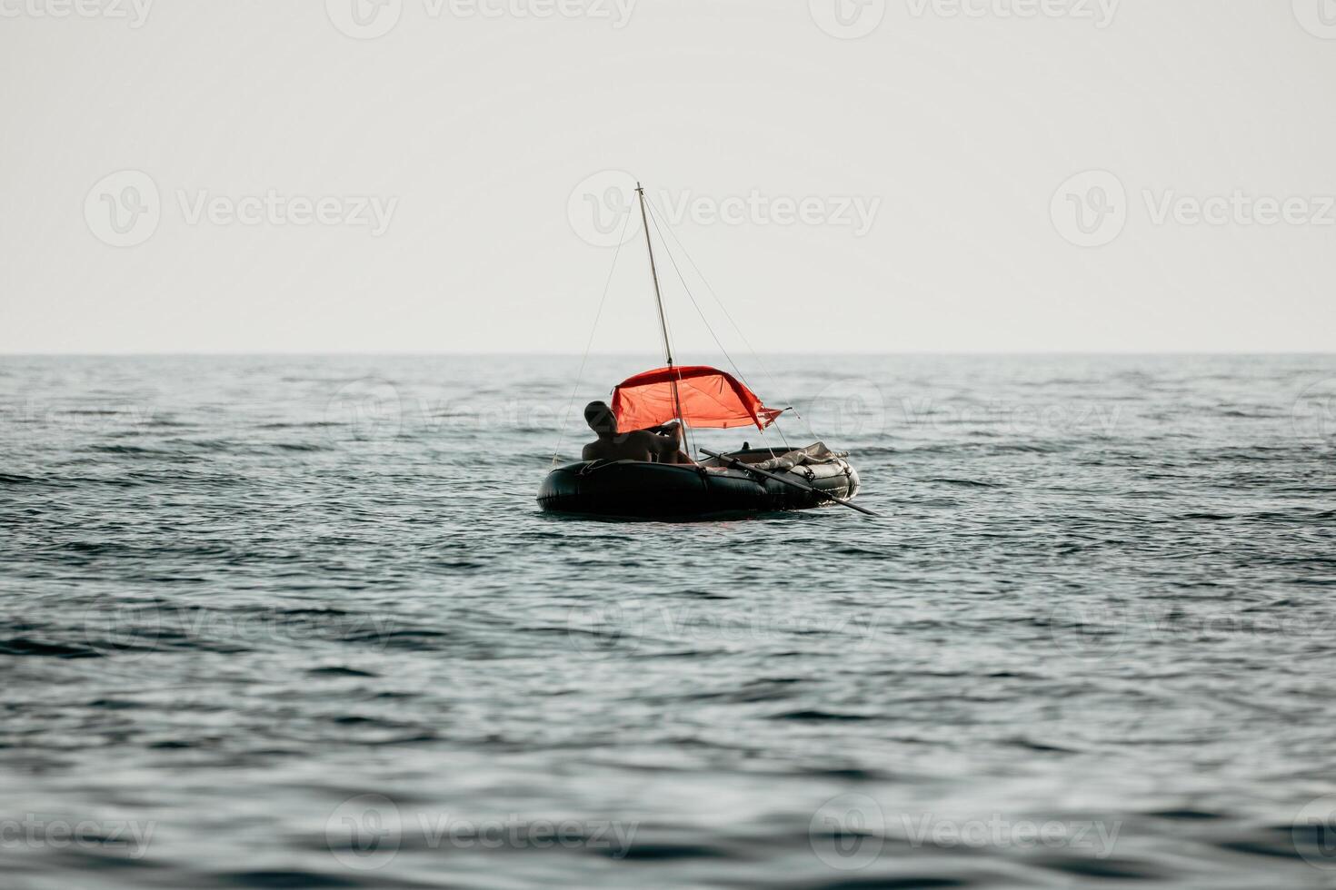 pescador mar barco. turista manobrando a inflável barco enquanto pescaria dentro uma vida jaqueta, com a lindo pôr do sol mar dentro a fundo. uma relaxante pescaria viagem. foto