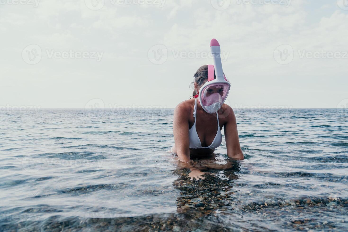 jovem feliz mulher dentro branco bikini e vestindo Rosa mascarar pega pronto para mar mergulho. positivo sorridente mulher relaxante e desfrutando água Atividades com família verão viagem feriados período de férias em mar. foto