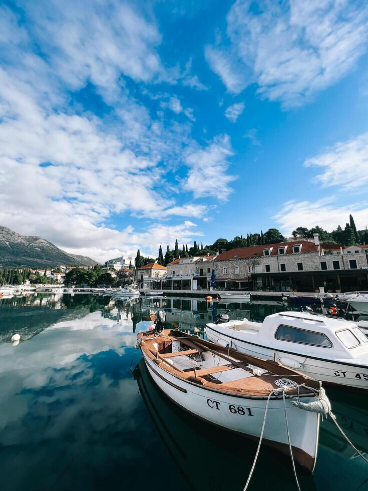 budva, Montenegro - 25 dezembro 2022. barcos estão ancorado às a beira-mar do a recorrer Cidade às a pé do a montanhas foto