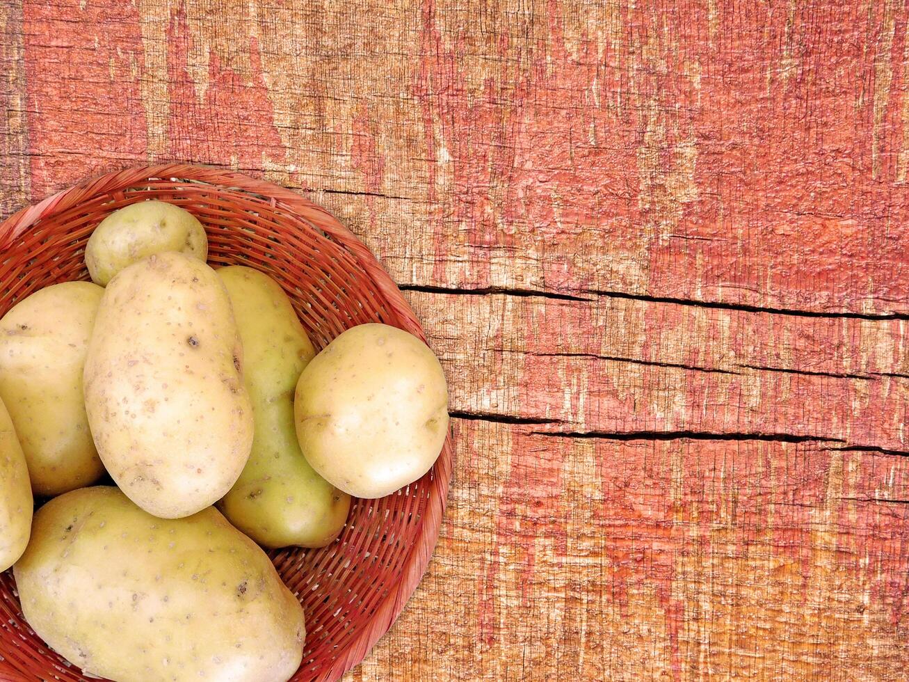 batatas em a de madeira fundo foto