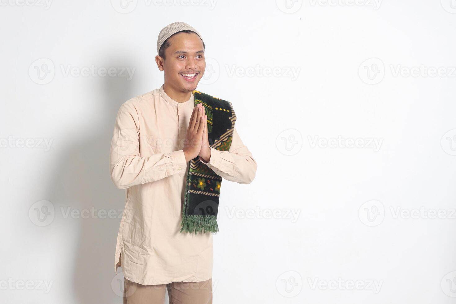 retrato do atraente ásia muçulmano homem dentro Koko camisa com oração esteira mostrando peça desculpas e bem-vinda mão gesto. desculpa durante eid mubarak. isolado imagem em branco fundo foto