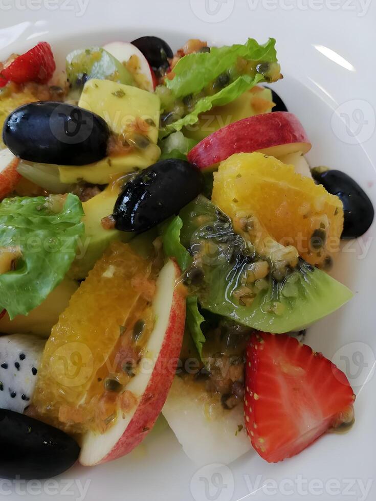 saudável Oliva e misturado fruta salada em branco prato foto