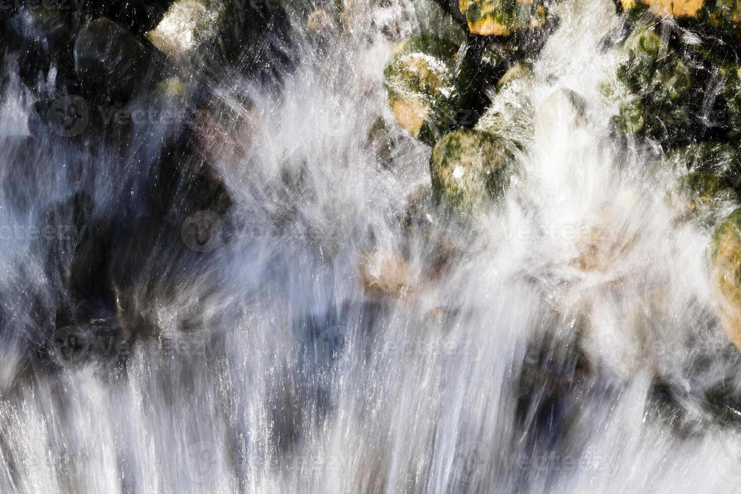 água corrente pulverização sobre musgo coberto pedras foto