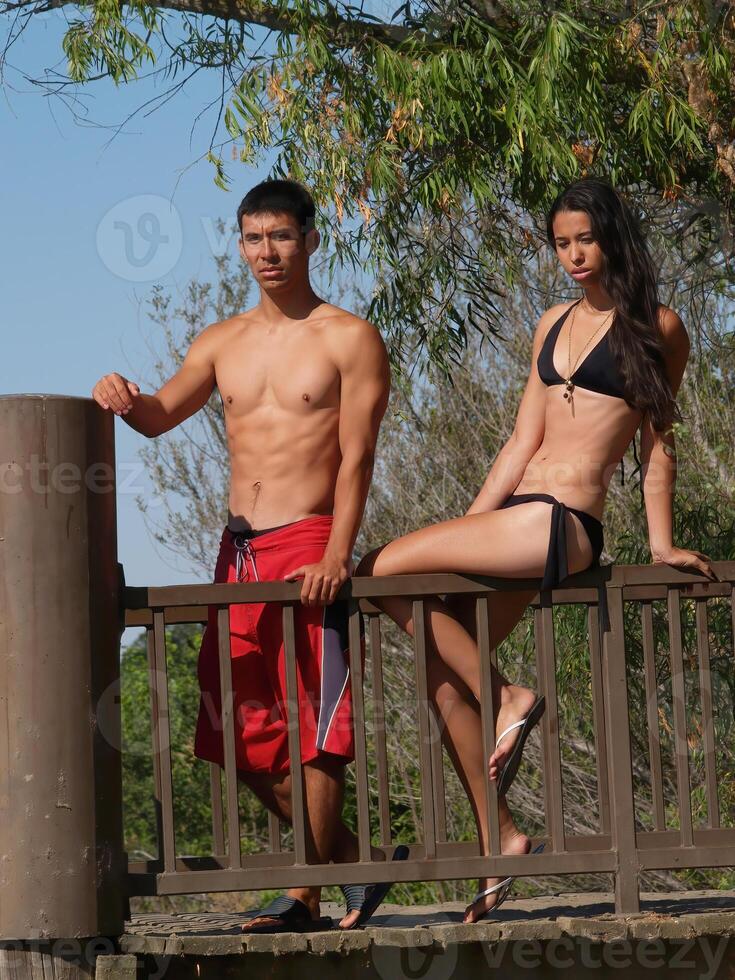 jovem homem e mulher dentro nadar ternos ao ar livre foto