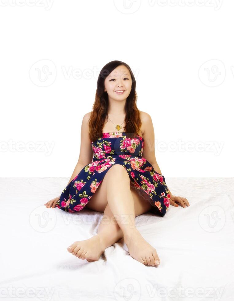 jovem chinês mulher sentado floral vestir sorridente foto