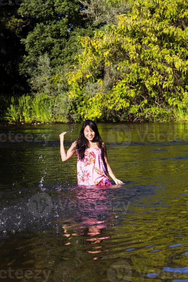 jovem japonês mulher espirrando rio vestir sorridente foto