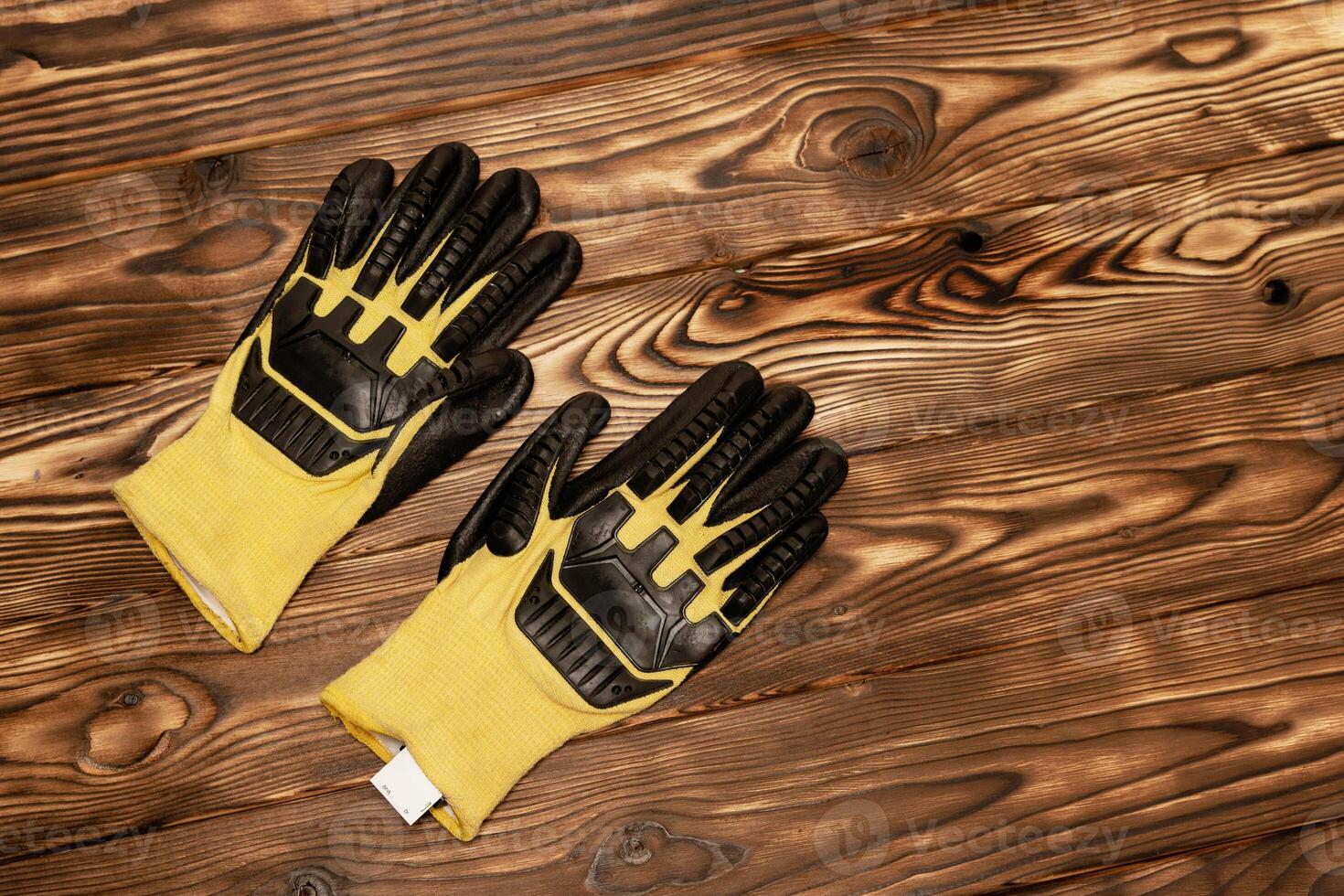 amarelo luvas em de madeira chão. uma par do brilhante amarelo trabalhos luvas com melhorada proteção contra cortes e solavancos. foto