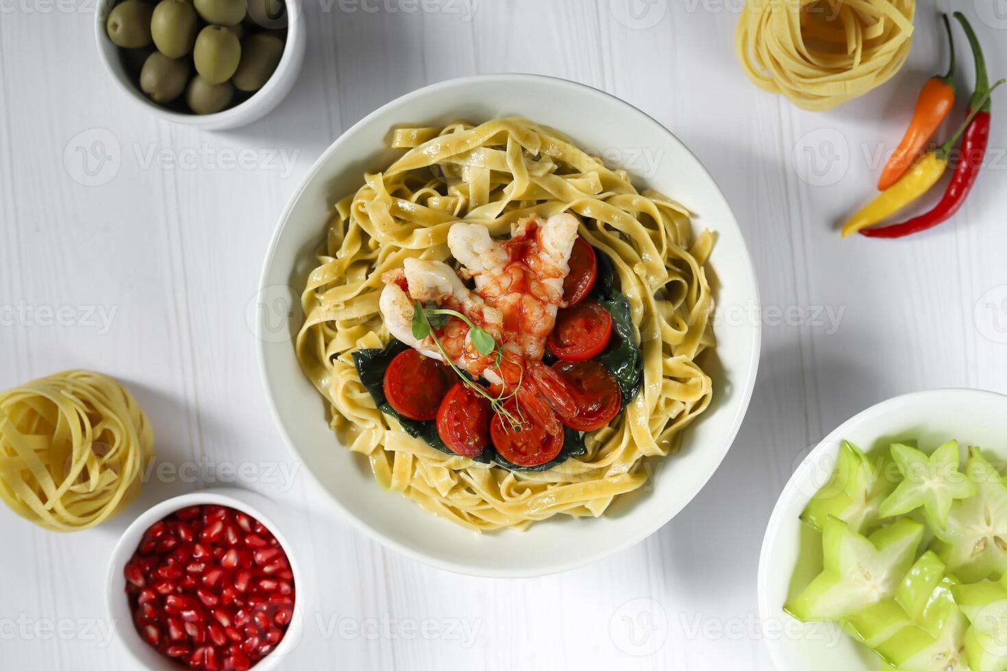 Macarrão com espinafre, tomates e camarão. frutos do mar. casa Produção. foto