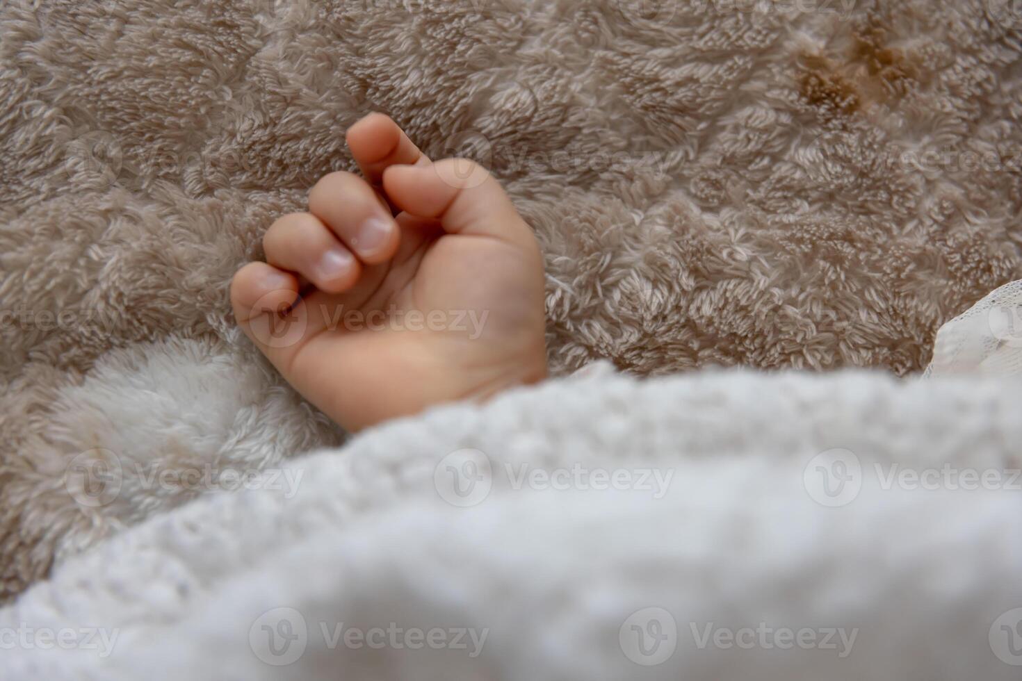 uma certo mão do dormindo ásia bebê em a tapete foto