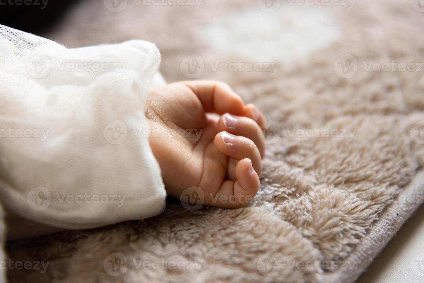 uma esquerda mão do dormindo ásia bebê em a tapete foto