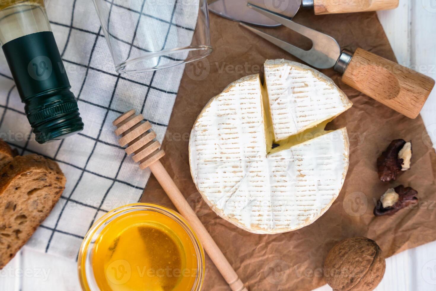 suave queijo queijo Camembert, mel, nozes e garrafa do vinho em a mesa para jantar. fechar-se. topo visualizar. seletivo foco. foto