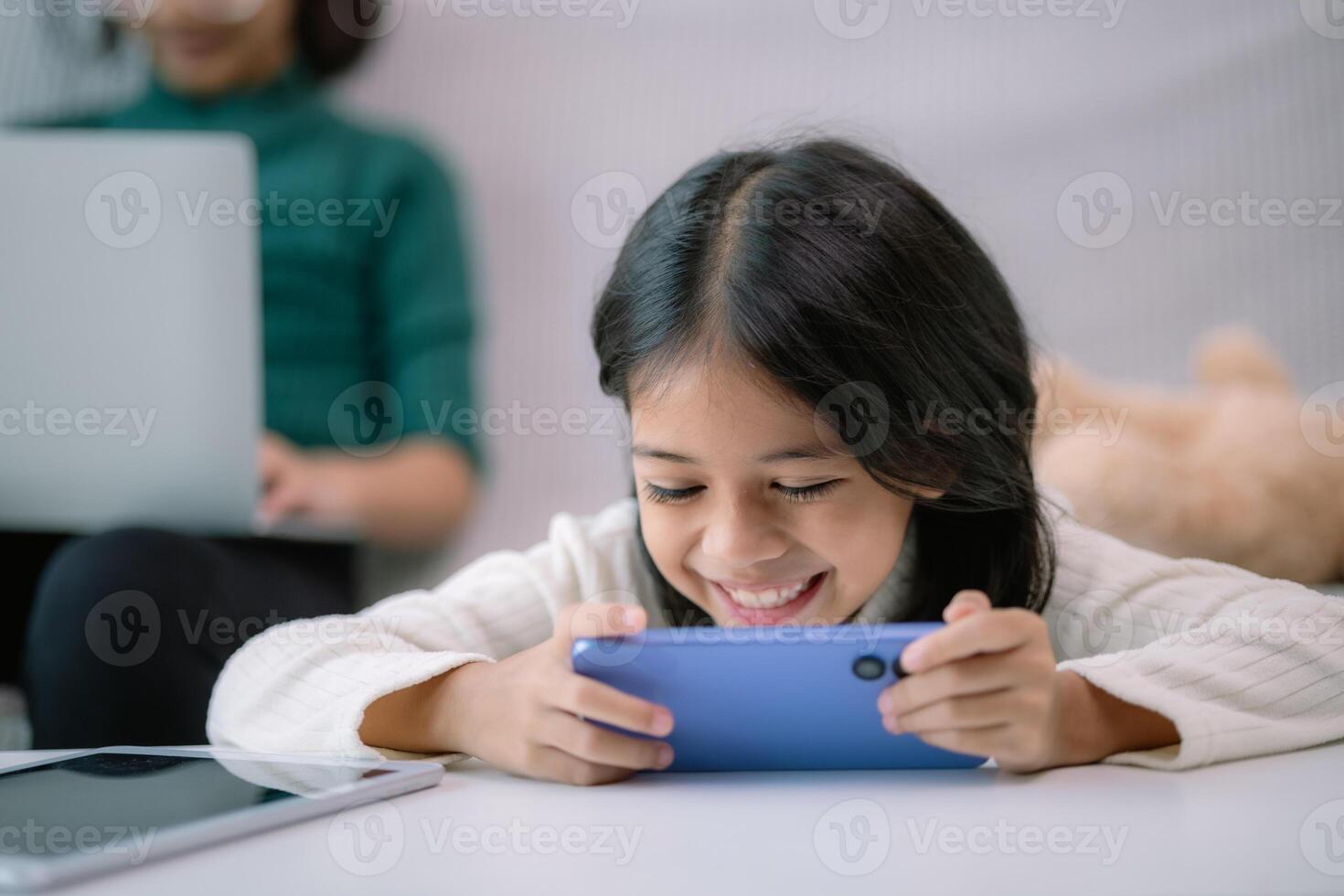 uma jovem menina é jogando uma vídeo jogos em uma célula telefone foto