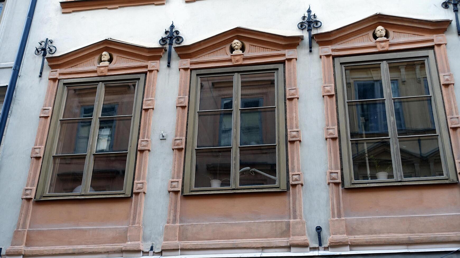 fachada do uma histórico construção dentro central Estocolmo. em a janelas você pode Vejo a cabeças do personagens a partir de italiano história. foto
