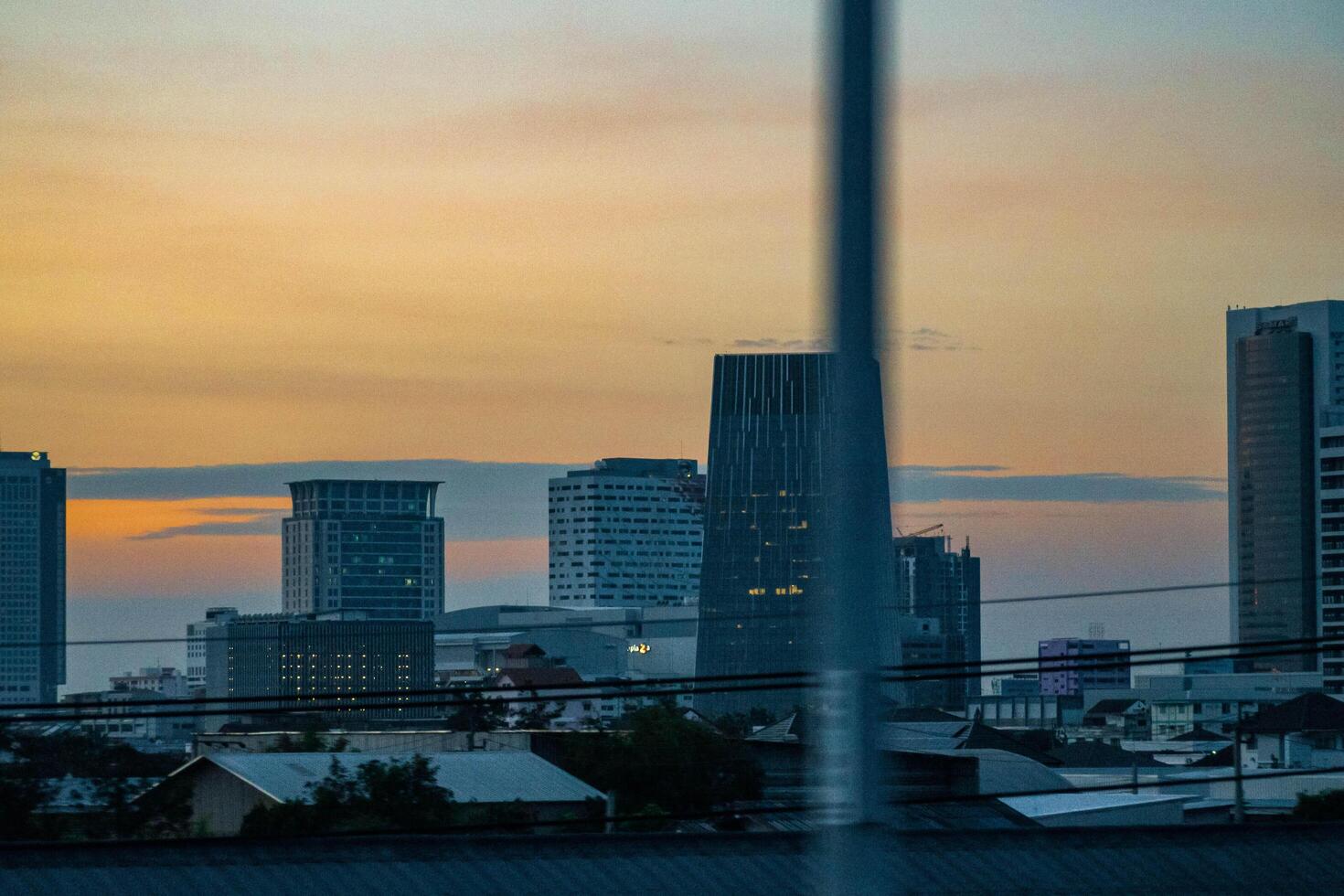 Bangkok, Tailândia, 2023 - crepúsculo aéreo fotografia do uma metrópole' edifícios com dourado céu. a lugares estão comercial o negócio distritos. foto