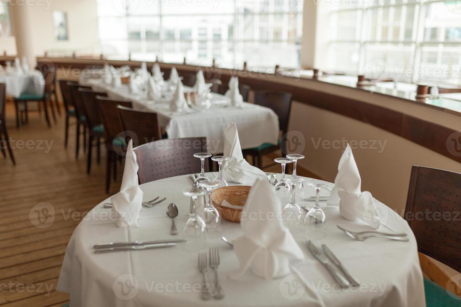 lindo mesa servido com artigos de vidro e talheres, preparado para festivo evento. especial ocasião celebrado dentro luxo restaurante ou cafeteria. mesa configuração conceito. Casamento mesa foto