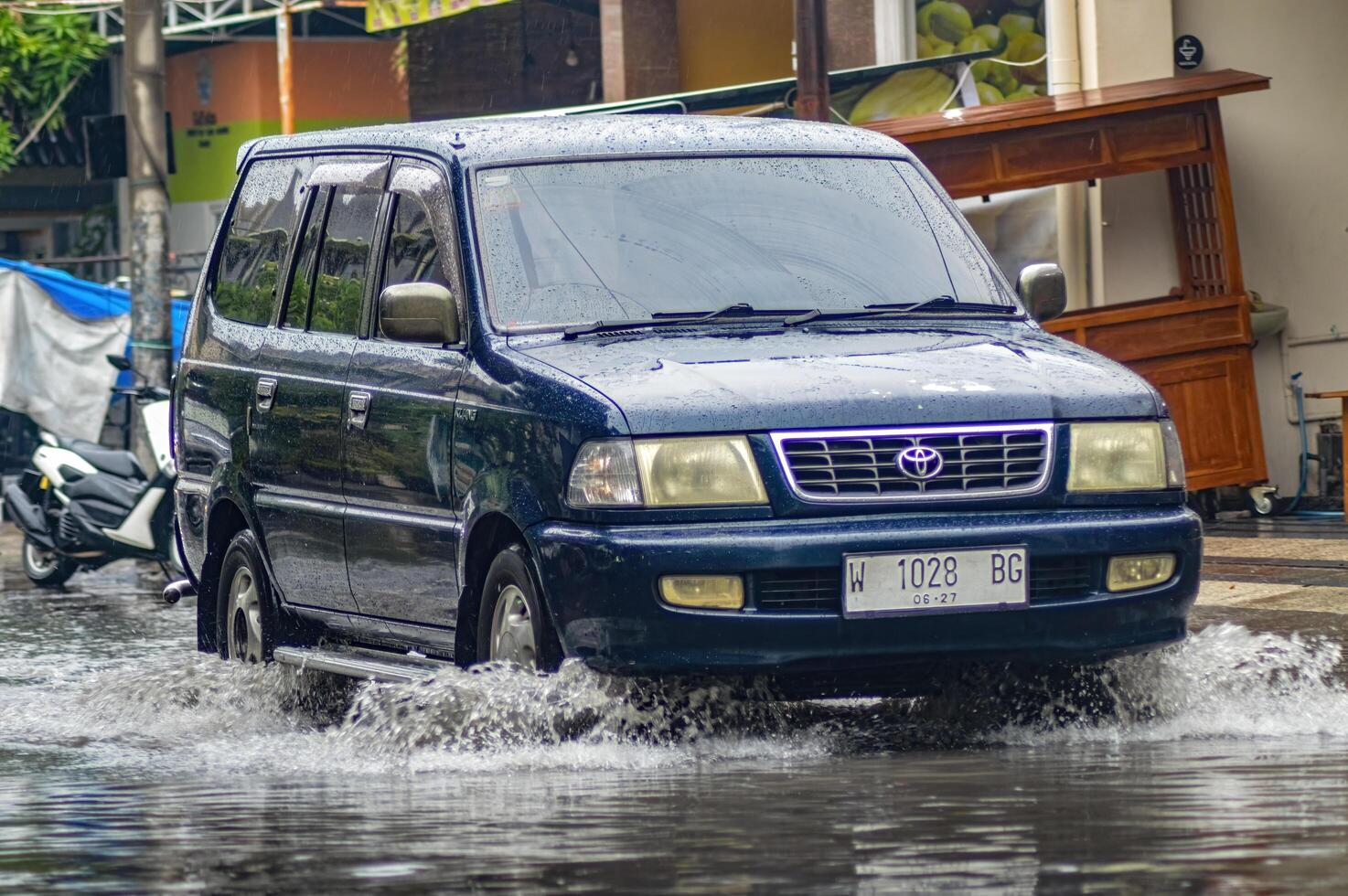 uma Toyota kijang carro este quebrou através inundação durante pesado chuva em uma residencial rua, Indonésia, 8 dezembro 2023. foto