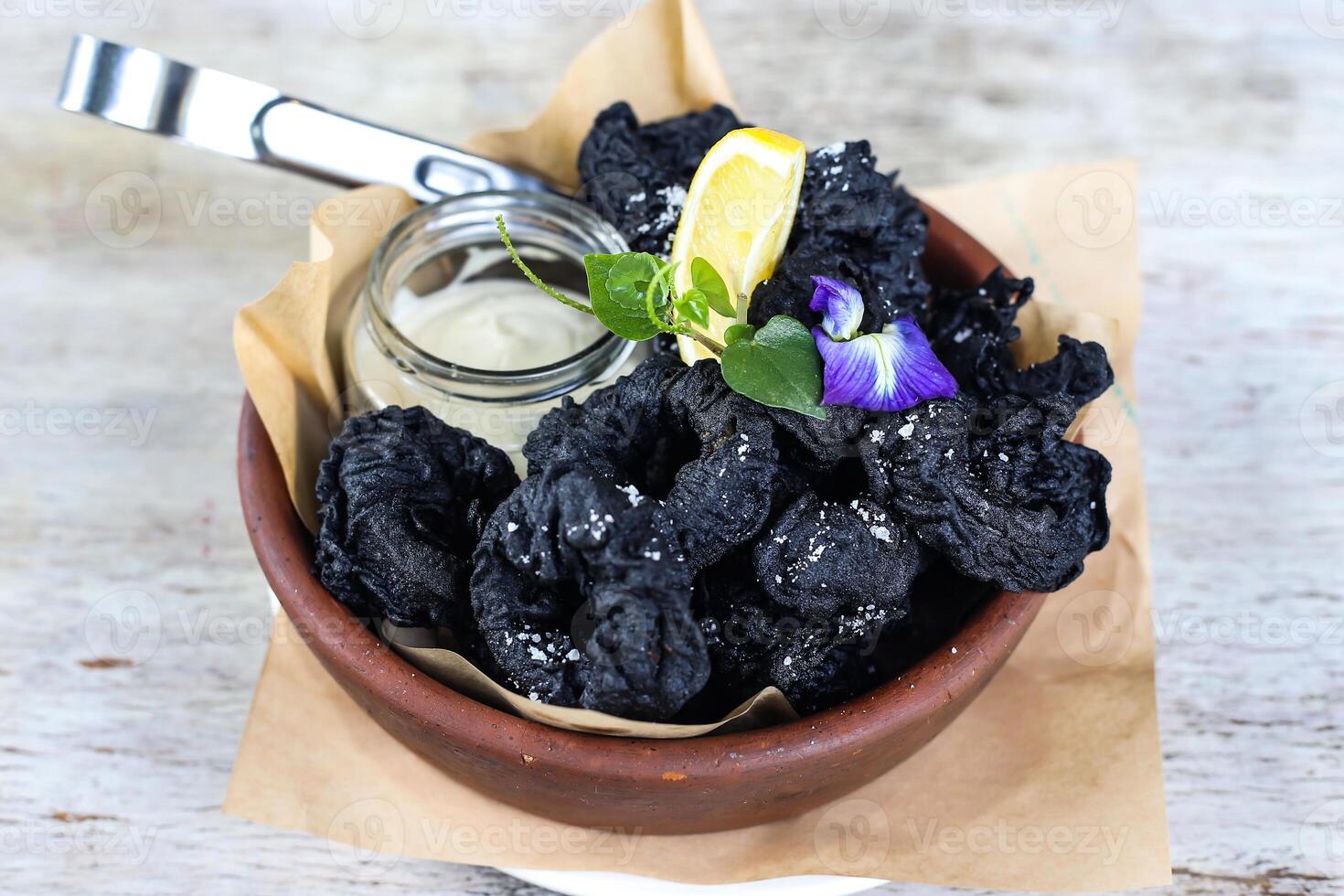 ativado carvão maltratado lula frito com mergulho e Lima servido dentro uma prato isolado em cinzento fundo lado Visão do lanches foto