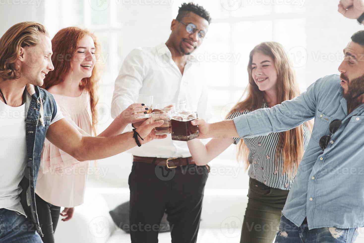 vamos tomar um drink. cinco funcionários multirraciais comemoram seu sucesso nos negócios foto