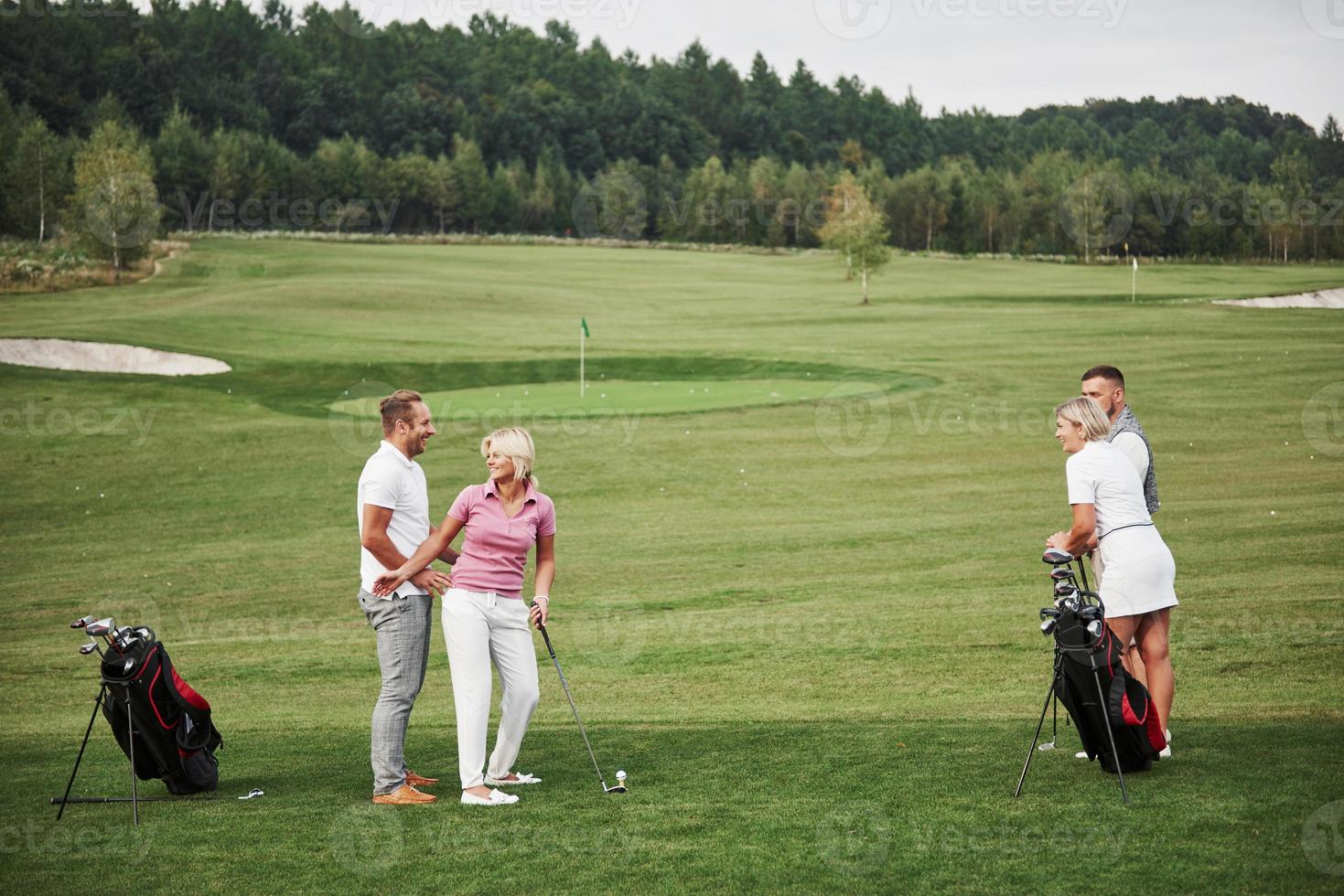 grupo de amigos estilosos no campo de golfe aprendem a jogar um novo jogo foto