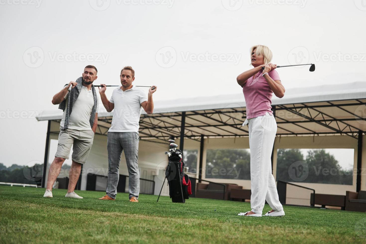 grupo de amigos estilosos no campo de golfe aprendem a jogar um novo jogo foto