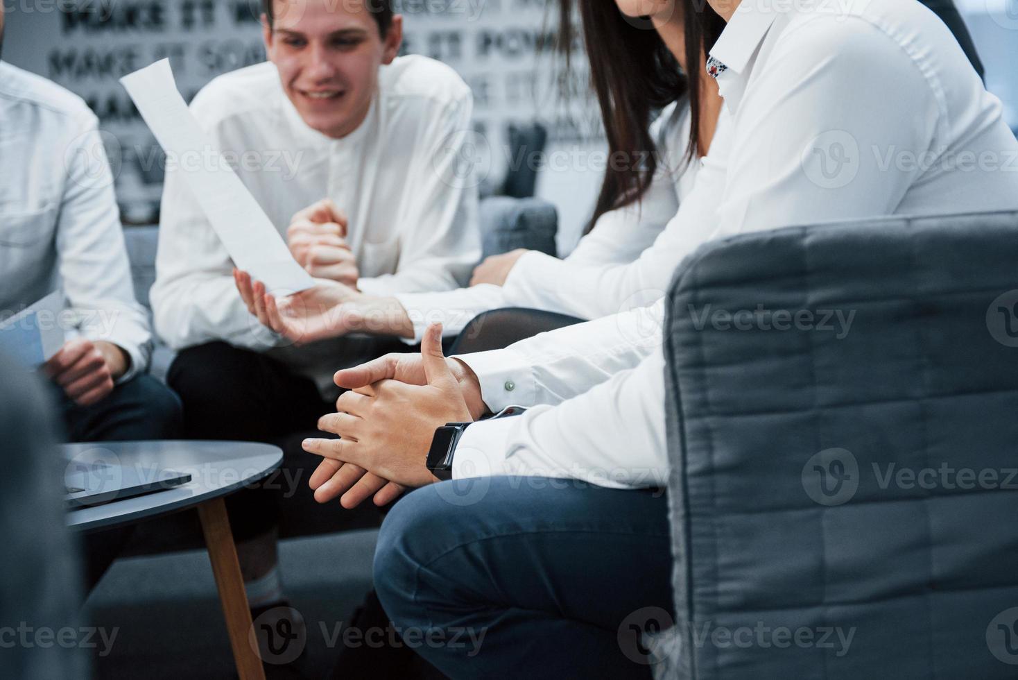 relógio elegante disponível. trabalhando juntos em uma atmosfera amigável usando o laptop na mesa foto