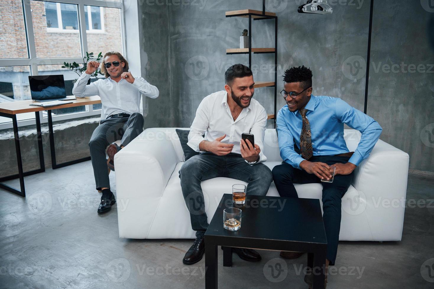 sorrindo durante o trabalho. grupo de funcionários multirraciais em roupas formais conversando sobre tarefas e planos foto