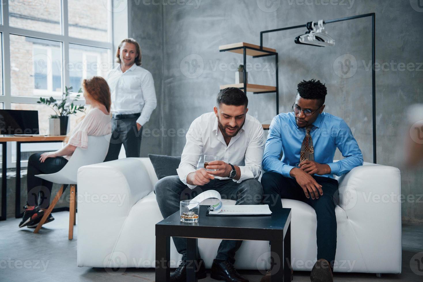 concentração em nuances. grupo de funcionários multirraciais em roupas formais conversando sobre tarefas e planos foto