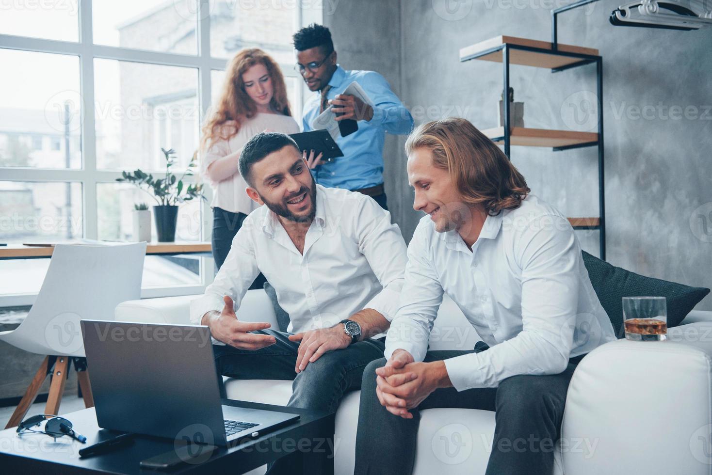 coworking pessoas. grupo de funcionários multirraciais em roupas formais conversando sobre tarefas e planos foto