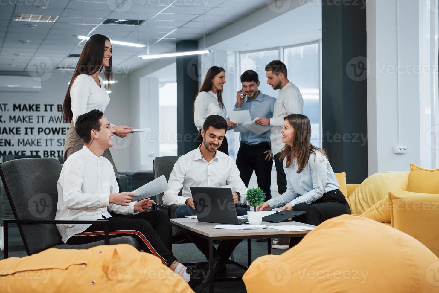 grupo de jovens freelancers no escritório conversando e sorrindo foto