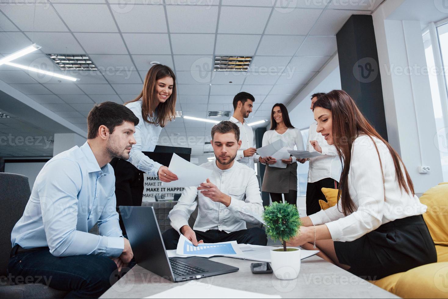 vista frontal. grupo de jovens freelancers no escritório conversando e sorrindo foto