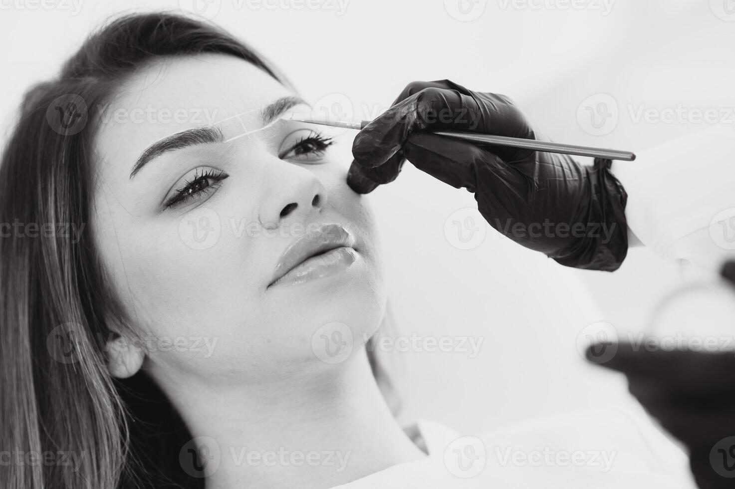 cosmetologista aplicando permanente faço acima em sobrancelhas- sobrancelha tatuagem foto