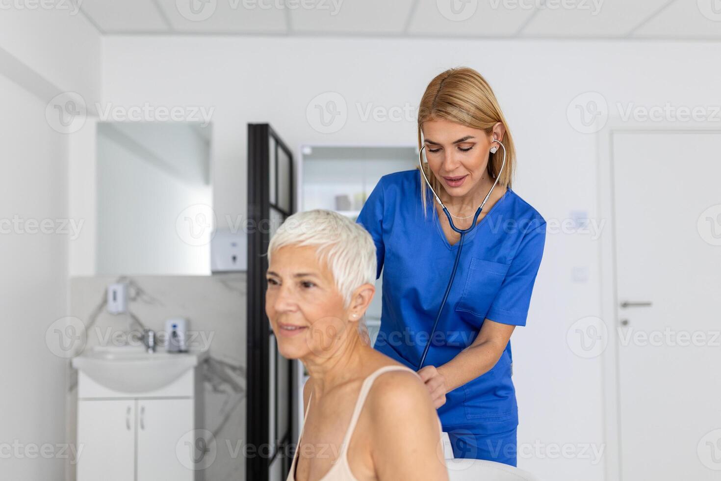 jovem fêmea médico ouço para Senior paciente coração peito com estetoscópio às clínica reunião. mulher gp checar examinar mulher cliente com estetoscópio. cuidados de saúde conceito. foto