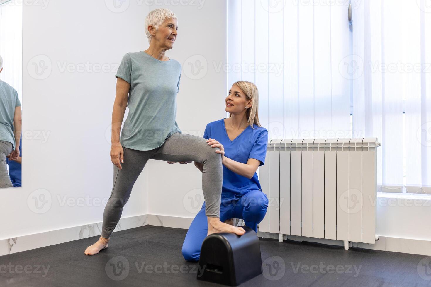 Senior paciente às a fisioterapia fazendo fisica exercícios com dela terapeuta, fazendo perna fisioterapia para idosos mulher, para tratar osteoartrite e nervo dor dentro a perna. foto