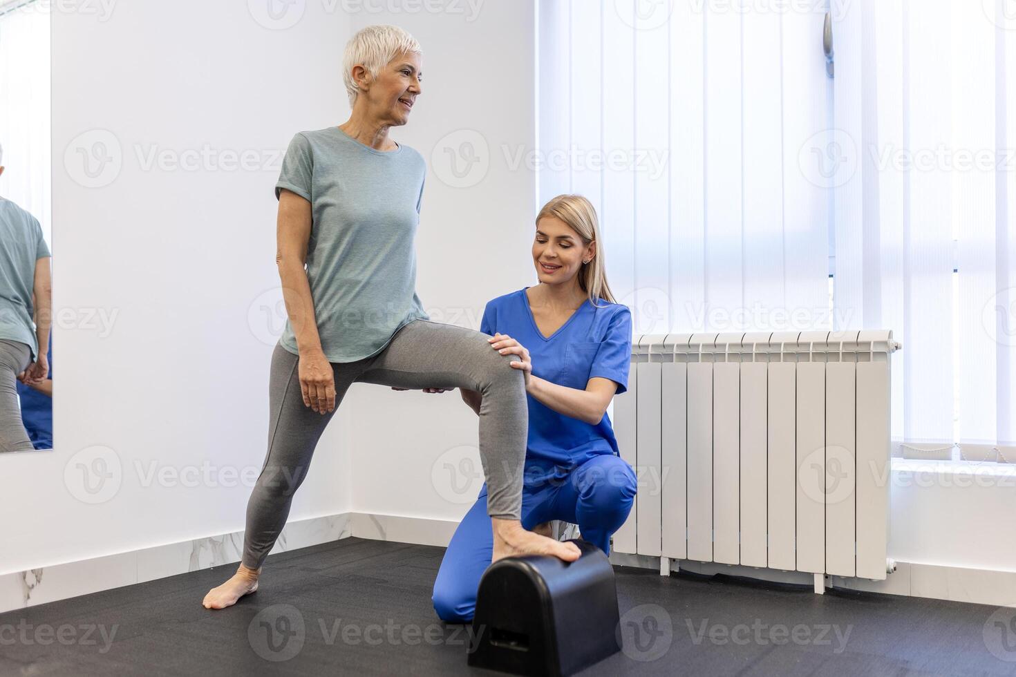 Senior paciente às a fisioterapia fazendo fisica exercícios com dela terapeuta, fazendo perna fisioterapia para idosos mulher, para tratar osteoartrite e nervo dor dentro a perna. foto