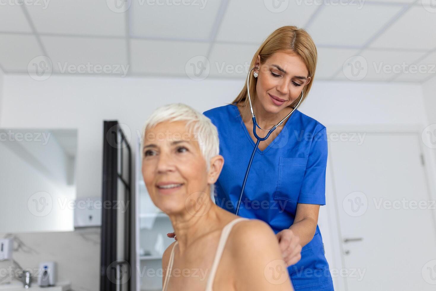 jovem fêmea médico ouço para Senior paciente coração peito com estetoscópio às clínica reunião. mulher gp checar examinar mulher cliente com estetoscópio. cuidados de saúde conceito. foto