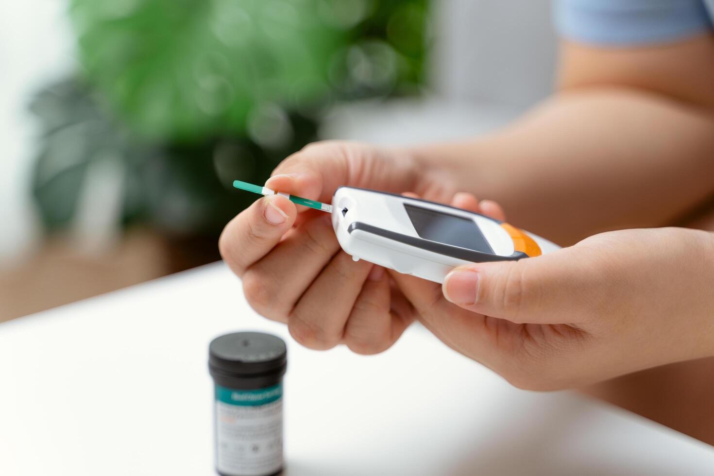 ásia mulher usando lanceta em dedo para verificação sangue açúcar nível de glicose metro, diabetes. foto