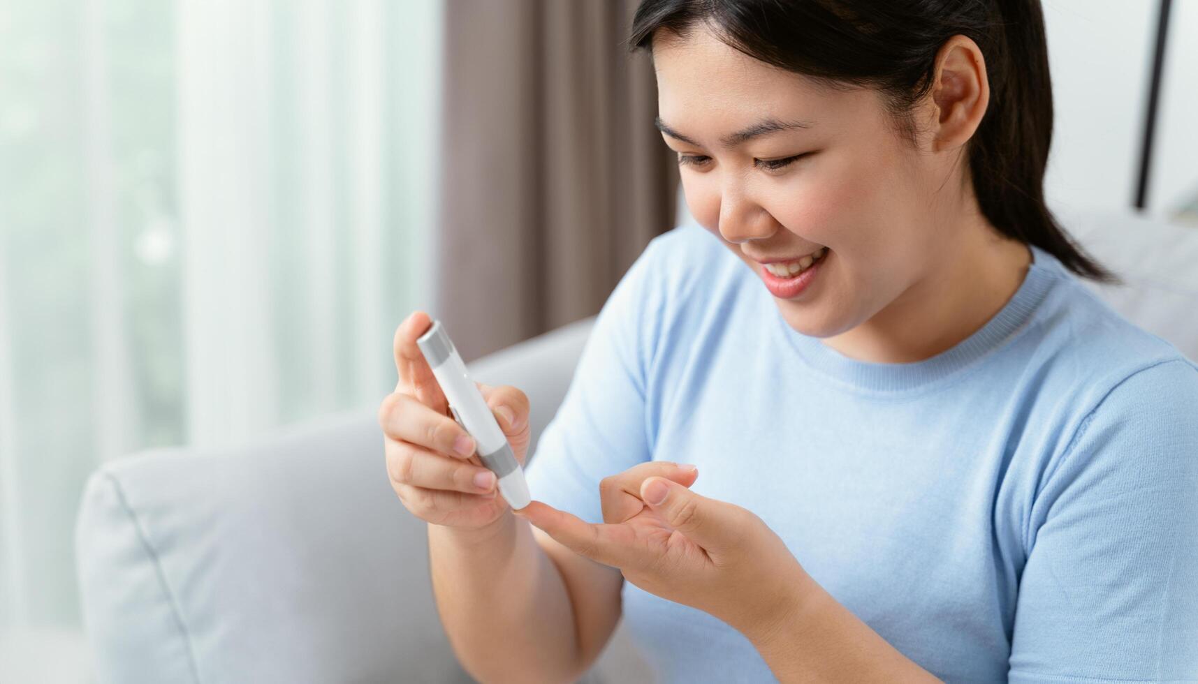 ásia mulher usando lanceta em dedo para verificação sangue açúcar nível de glicose metro, diabetes. foto