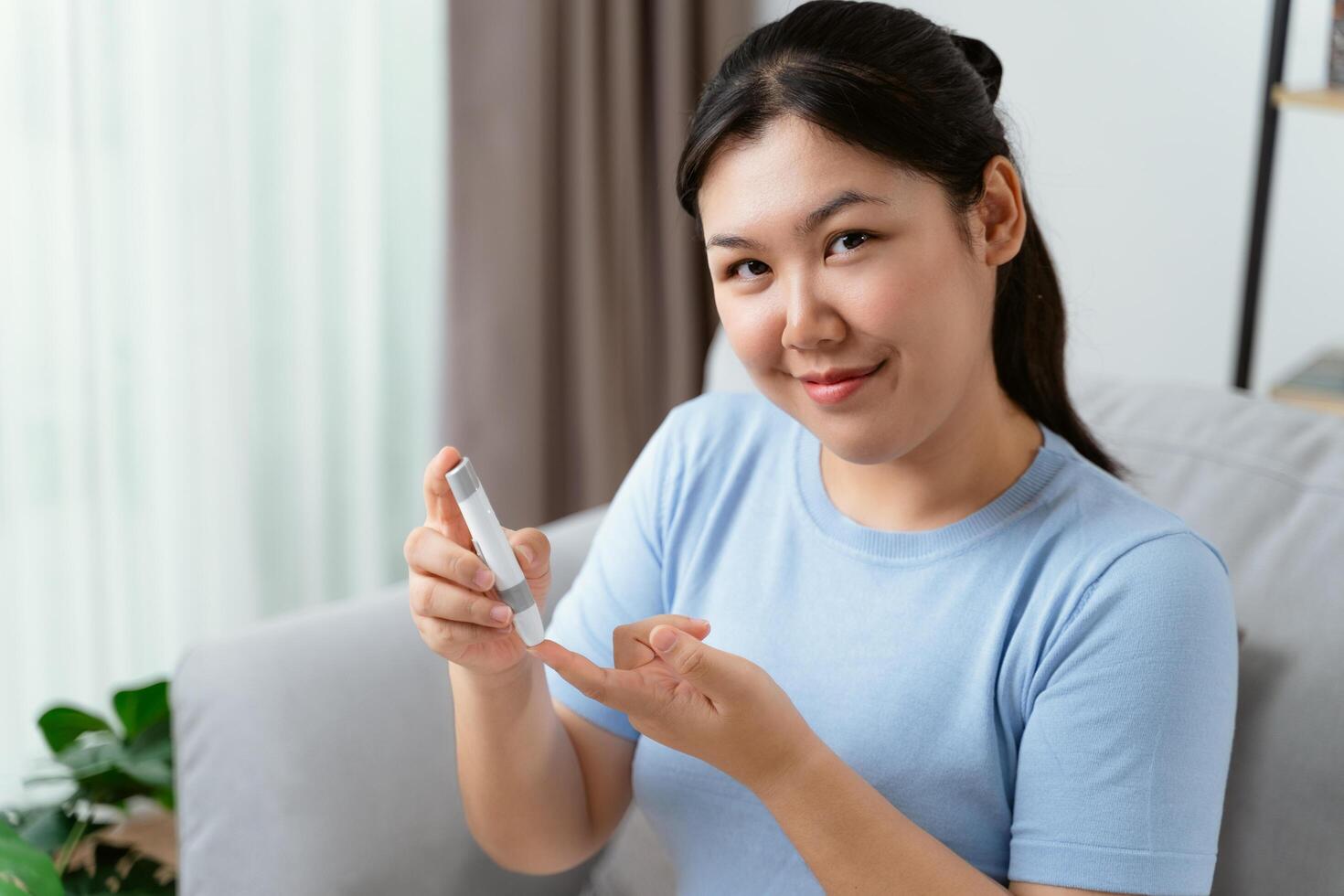 ásia mulher usando lanceta em dedo para verificação sangue açúcar nível de glicose metro, diabetes. foto