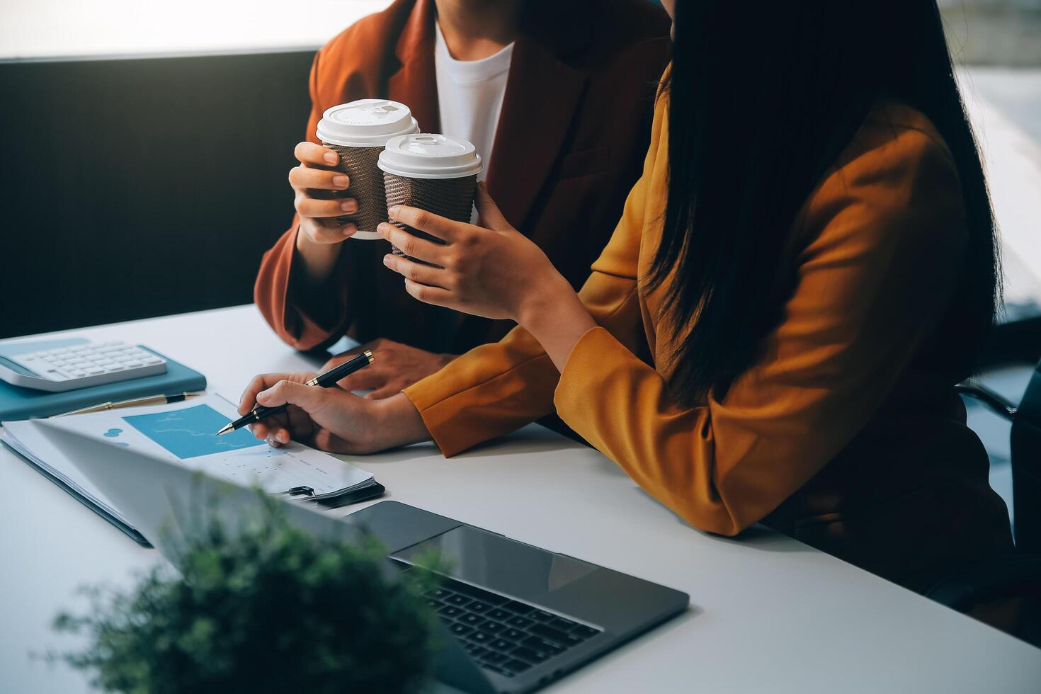 bela jovem sorridente empresária asiática trabalhando no laptop e bebendo café, empresária asiática trabalhando finanças de documentos e calculadora em seu escritório. foto