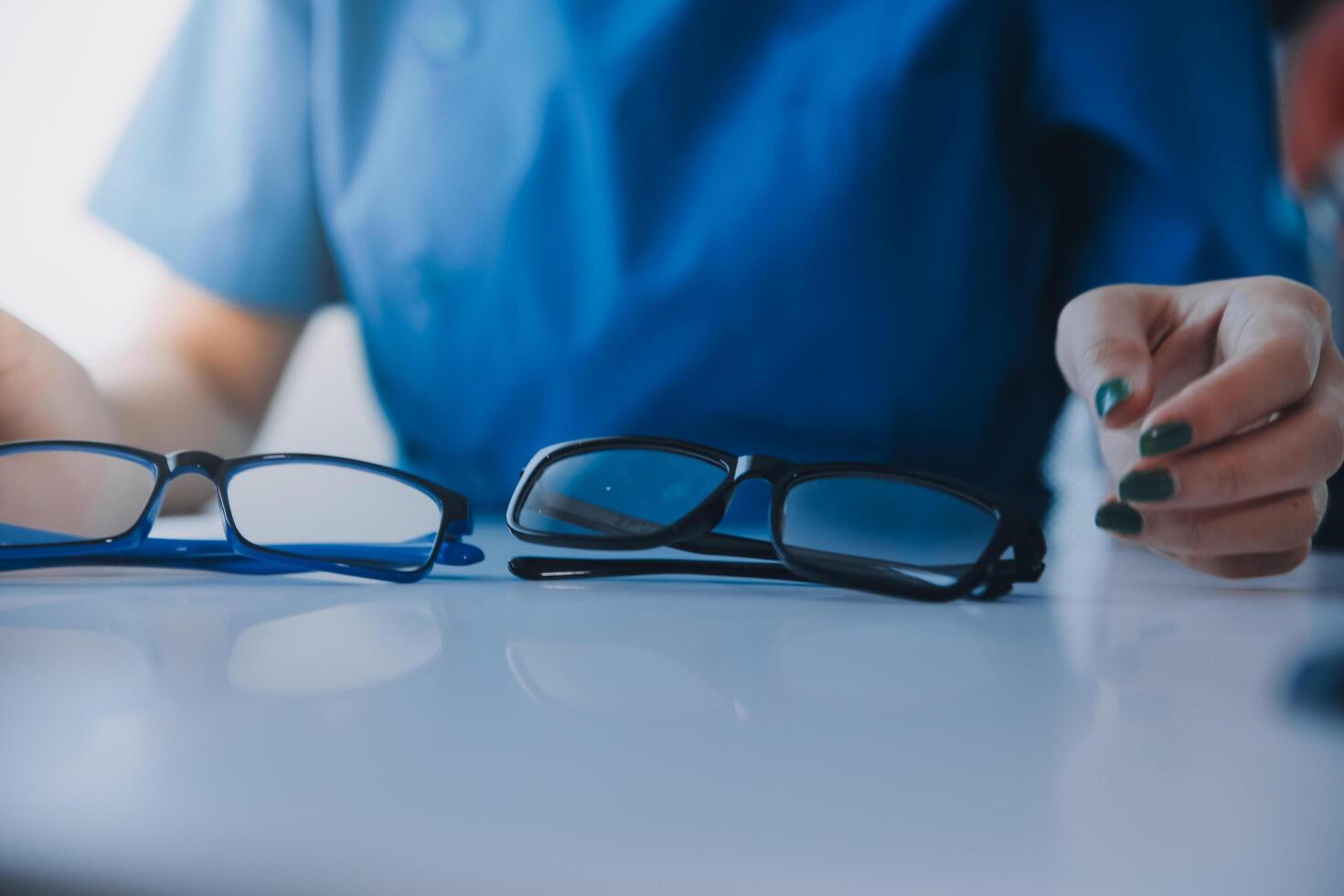 fechar-se do ásia fêmea médico falando com idosos paciente mostrando globo ocular modelo e explicando olho doença dentro hospital foto