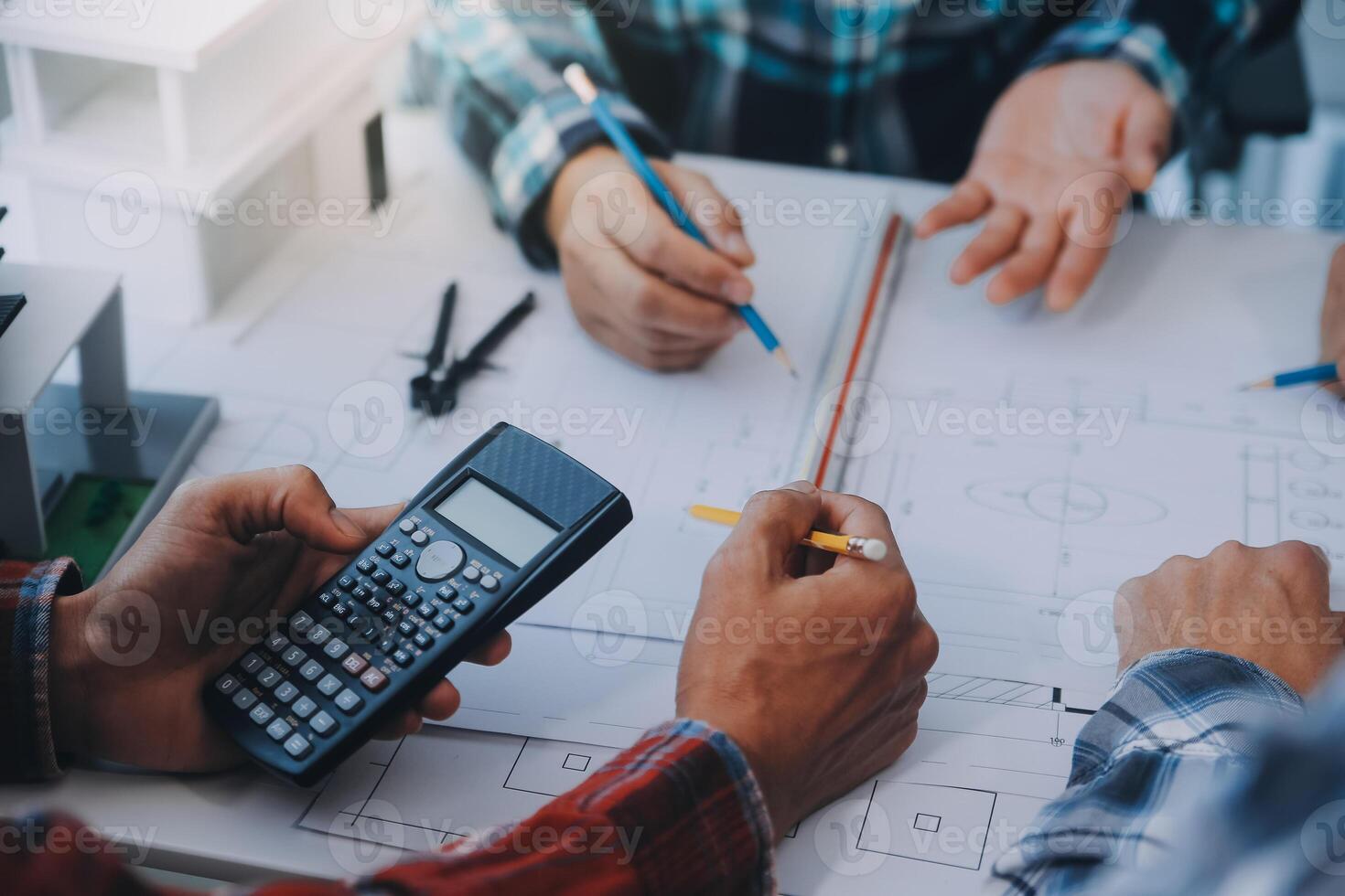 engenheiro pessoas encontro trabalhando e apontando às uma desenhos dentro escritório para discutindo. Engenharia Ferramentas e construção conceito. foto