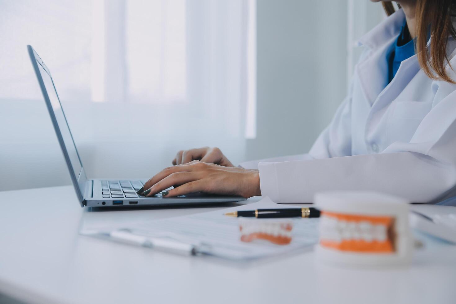 dentistas estão discutindo problemas dentários na imagem de raio-x do relatório na tela do laptop para os pacientes. foto