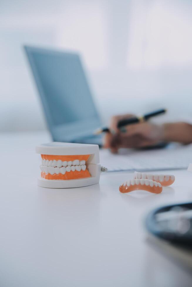 dentistas estão discutindo problemas dentários na imagem de raio-x do relatório na tela do laptop para os pacientes. foto