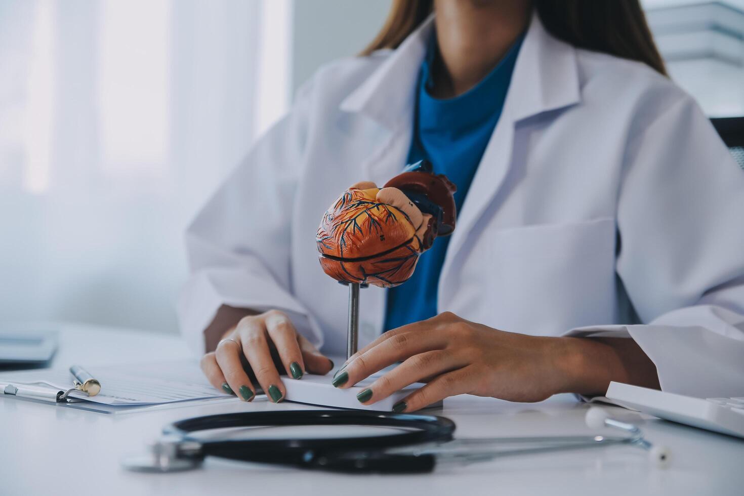 médico explicando coração para idosos paciente. médico explicando a coração modelo. médicos caneta ponto para uma modelo do a coração foto