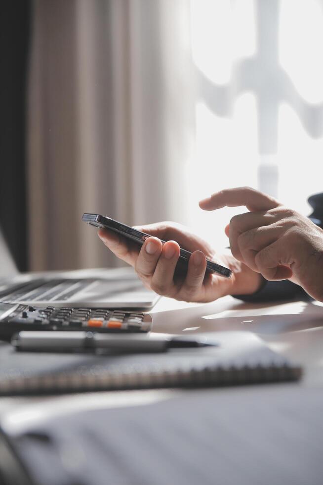 lado Visão tiro do uma do homem mãos usando inteligente telefone dentro interior, traseiro Visão do o negócio homem mãos ocupado usando célula telefone às escritório mesa, jovem masculino aluna digitando em telefone sentado às de madeira mesa, flare foto