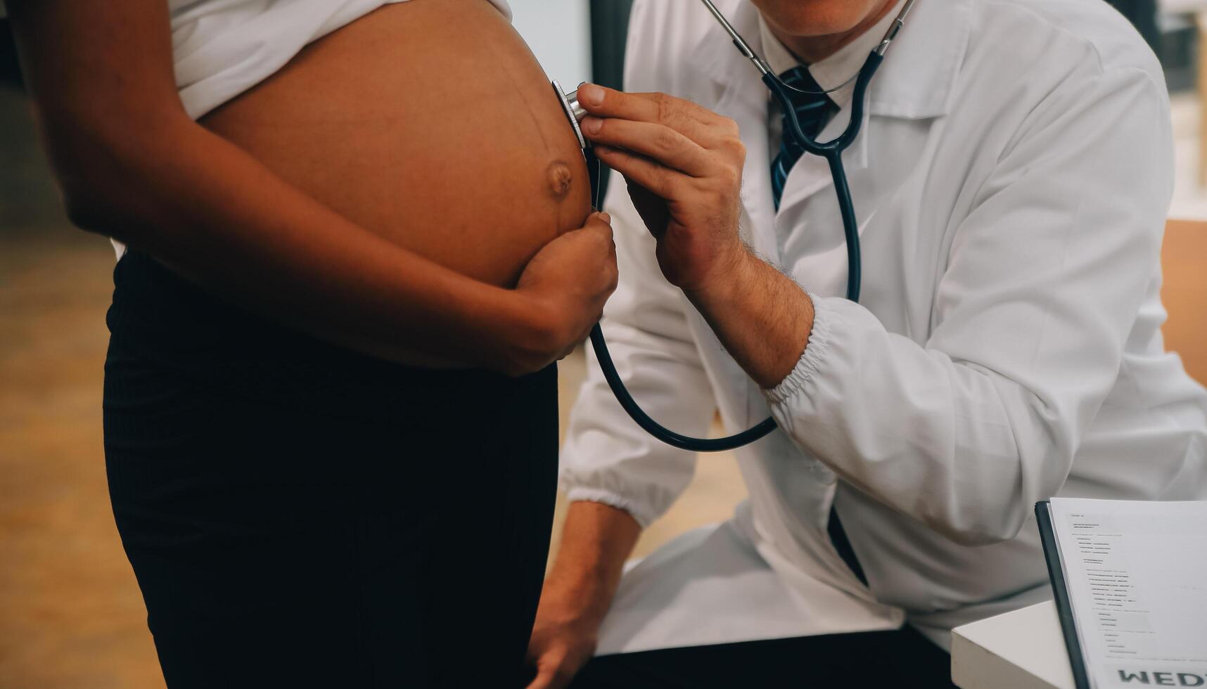 fêmea médico é verificação grávida mulher com estetoscópio. conceito carinhoso para grávida mulher foto