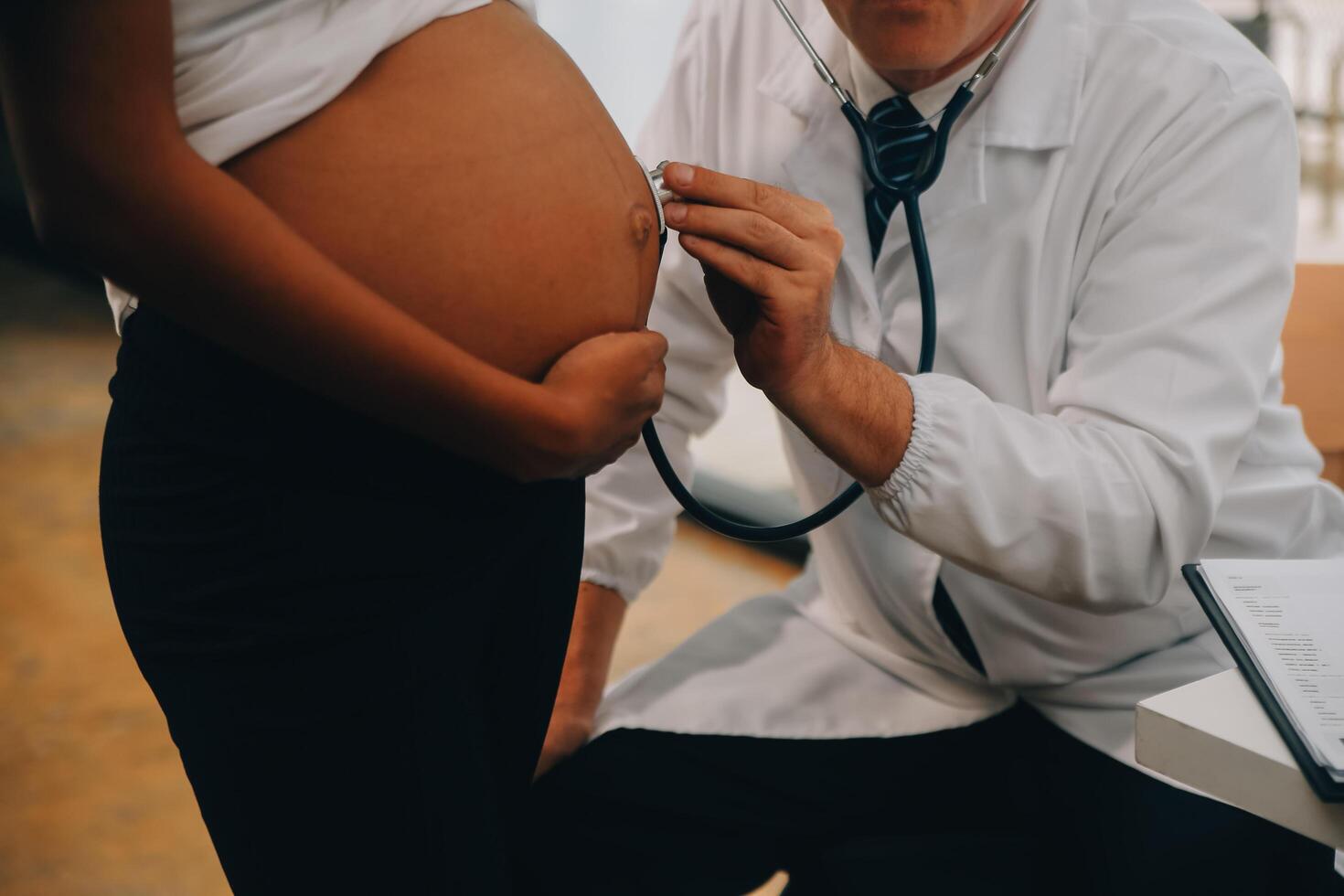 fêmea médico é verificação grávida mulher com estetoscópio. conceito carinhoso para grávida mulher foto